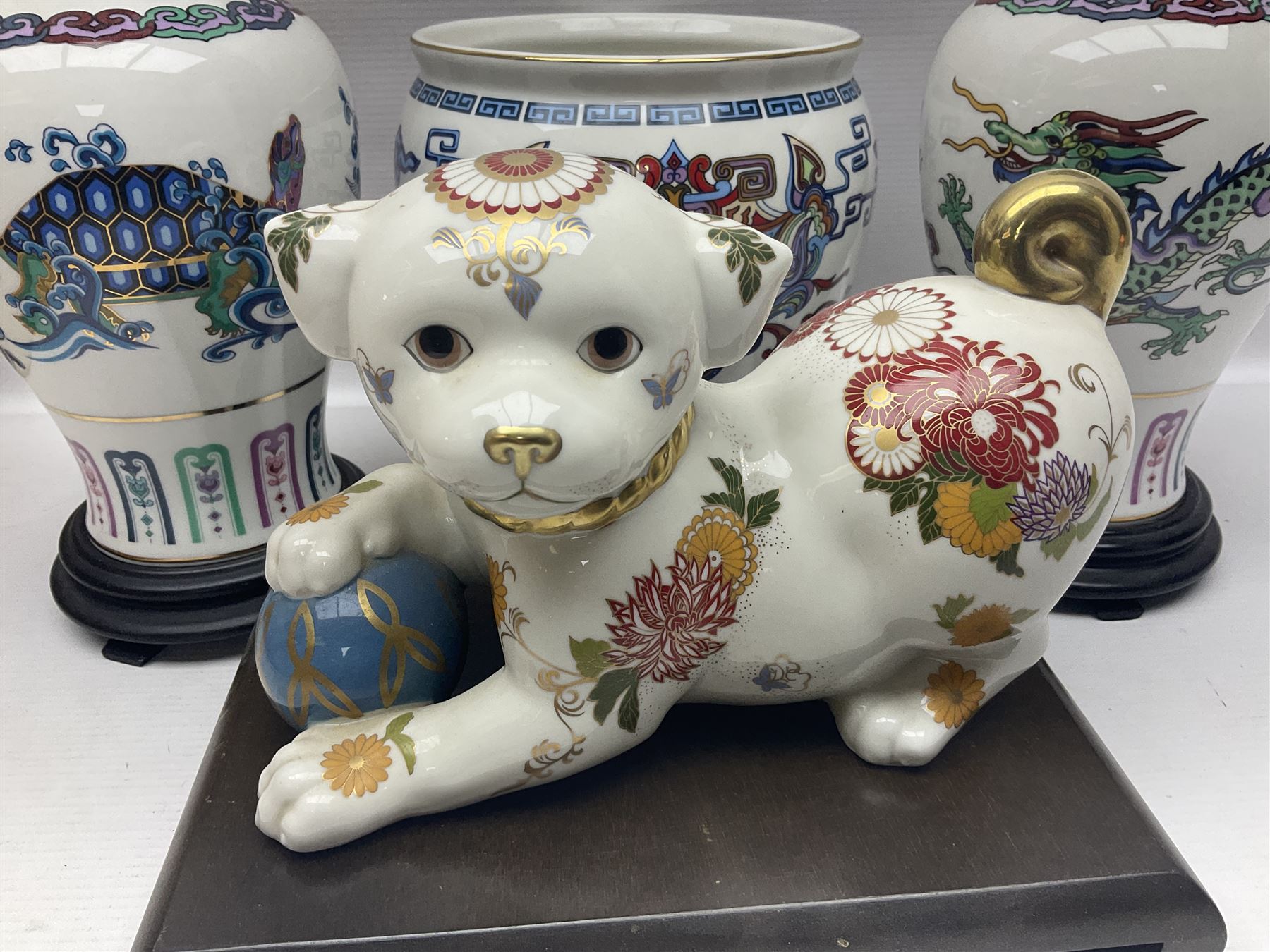 Franklin Mint Chinese style ceramics, comprising two vases, puppy and a planter, all on wooden stands
