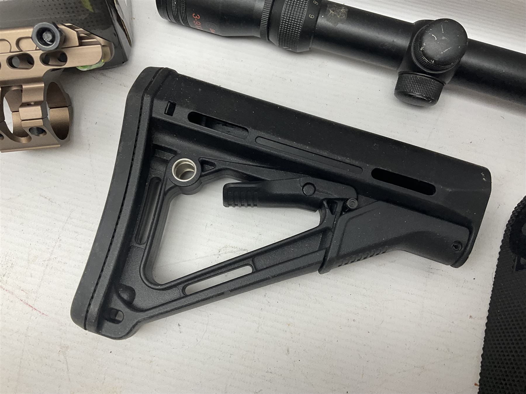 Assorted shooting accessories including two telescopic sights, red dot sight,  two bi-pods, spirit level mount, two gun butts and two forward handles