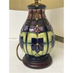 Moorcroft table lamp, of baluster form, decorated in the Violet pattern, on wooden plinth, with accompanying cream shade of lobed form, with piped detail, H23cm (excluding fitting)