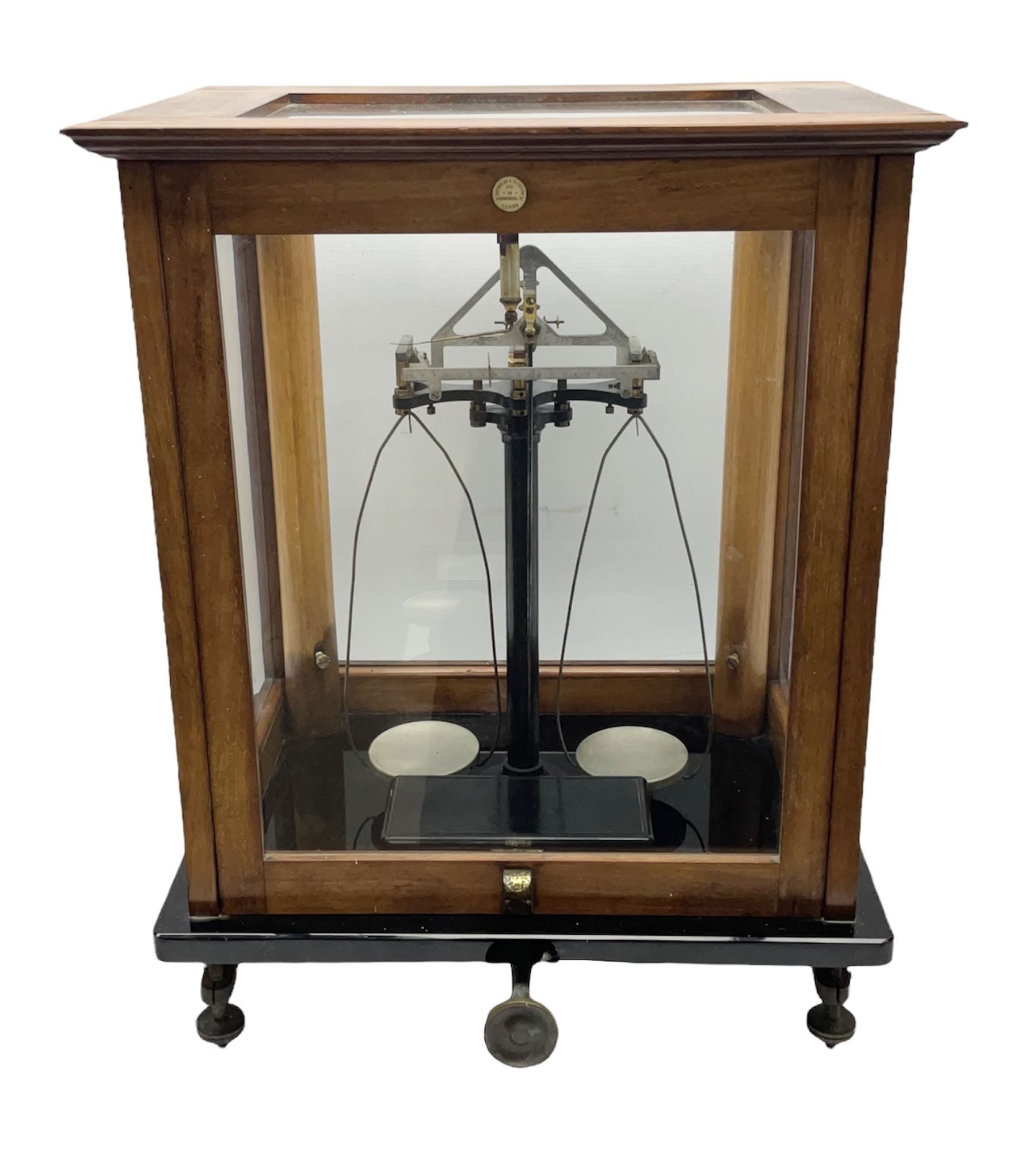 Set of laboratory balance scales by Reynolds & Branson of Leeds in fully glazed mahogany case with rise-and-fall front door, black vitrolite base with brass feet and hand cranked action L40cm H51.5cm D30cm; and bakelite cased set of brass weights
