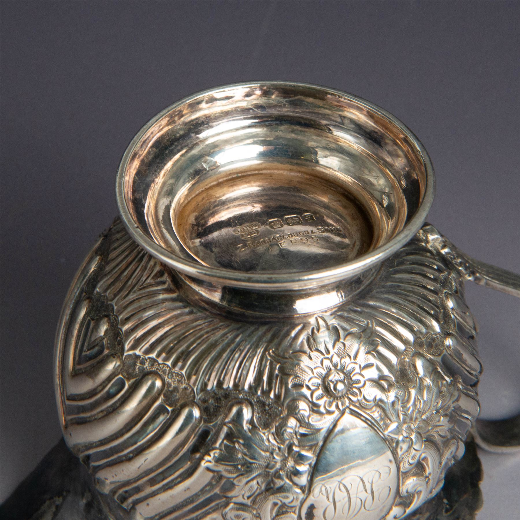 Victorian silver four piece tea service, comprising hot water pot, teapot, milk jug and sugar bowl, of circular part fluted bellied form, with embossed and engraved floral decoration, engraved with initials to body, the teapot and hot water pot with wooden handles and finials, hallmarked Z Barraclough & Sons, Sheffield 1898