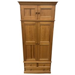 Solid pine double wardrobe, fitted with top box, enclosed by panelled doors, two short and one long drawer, on plinth base 