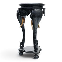 Elephant ebonised jardinière, moulded circular top raised on carved Elephant supports united by a shaped undertier