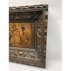 Late 17th/early 18th century oak, ebony and fruitwood marquetry panel depicting two birds perched upon a central stylised flower, within a later foliate carved oak frame, H39.5cm W54cm
