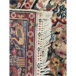 Persian design ivory ground rug, the field decorated with flower heads and trailing branches within pillars and cusped arches, the blue ground border with repeating floral design, within guard stripes 