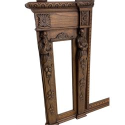 Late 19th century carved oak overmantle mirror, arched top with foliate carved edge and two turned acorn finials, triple bevelled plate front with carved figural pilasters decorated with fruit and trailing branch
