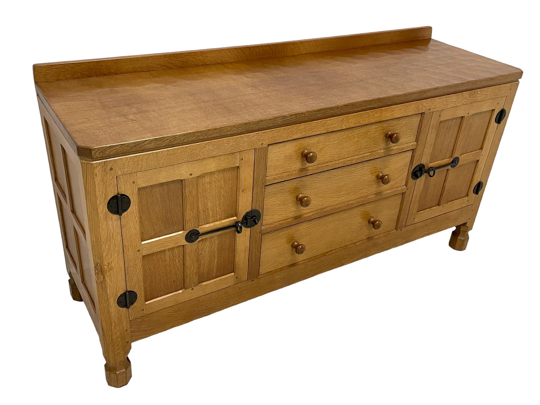Mouseman - oak dresser, rectangular adzed top with raised back over three central drawers and two flanking cupboards, enclosed by panelled doors with wrought metal fixtures, the canted upright carved with mouse signature, on octagonal feet, by the workshop of Robert Thompson, Kilburn