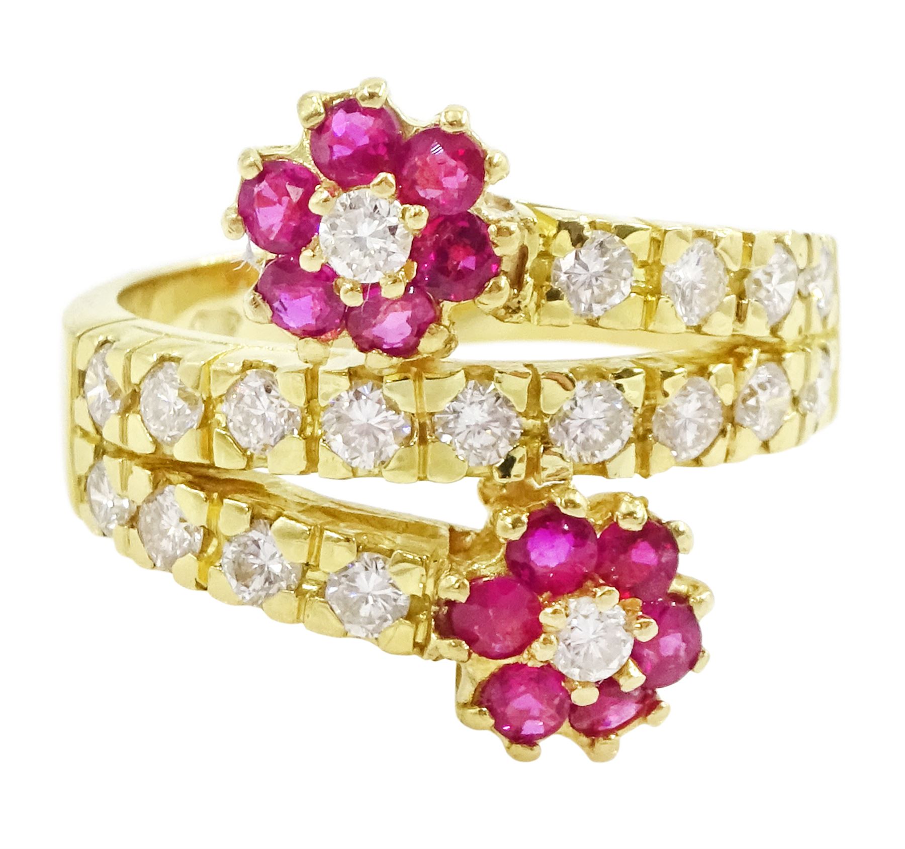 18ct gold ruby and diamond flower head crossover ring, two flowers each set with a single round brilliant cut diamond and six rubies, to diamond set stems and spaced by a row of nine diamonds, stamped 750, total diamond weight approx 0.55 carat