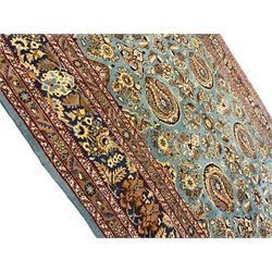 Central Persian Qum pale blue ground rug, the field decorated with stylised plant motifs surrounded by trailing foliate vine patterns in a symmetrical format, the multi-band guarded indigo border decorated with repeating flowerheads 