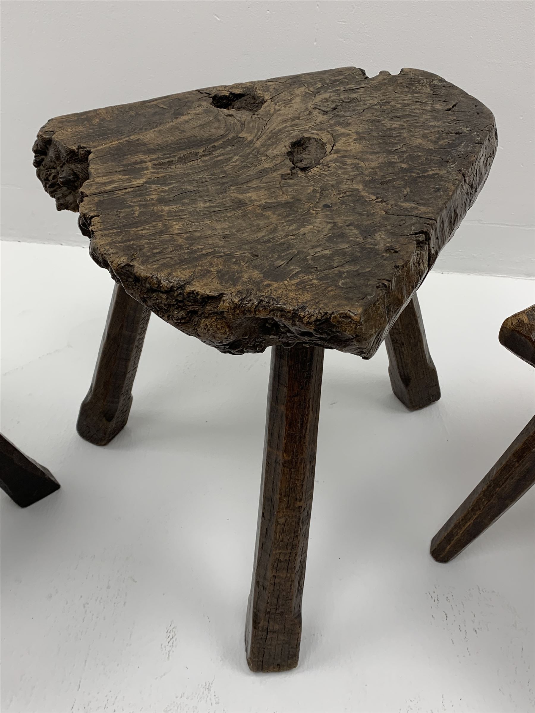 Collection of three mid 20th century stools by Jack Grimble of Cromer - rectangular tooled oak seat on four splayed supports (38cm x 31cm, H35cm), circular tooled burr oak seat on three supports (D29cm, H35cm), shaped burr top on three supports (L44cm, H45cm), each signed underneath