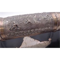 Late 19th/early 20th century Indian silver scroll holder, of cylindrical form with vacant cartouche and embossed with figures, animals and huts, upon a shaped ebonised stand with silver supports and silver panel of India, scroll L41cm, approximate weight of scroll 14.89 ozt (463.3 grams)