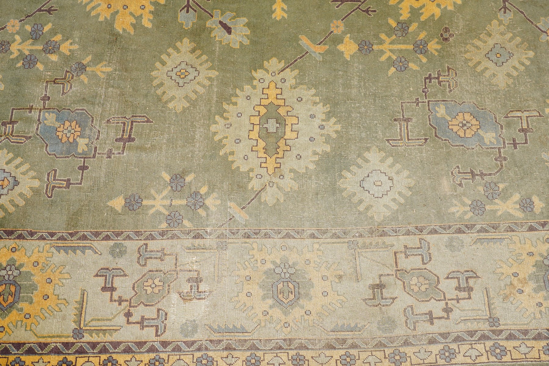 Lage Turkish Oushak green ground carpet, the field decorated with large stylised plant motifs and geometric design, the sage green guard band with further repeating foliate motifs