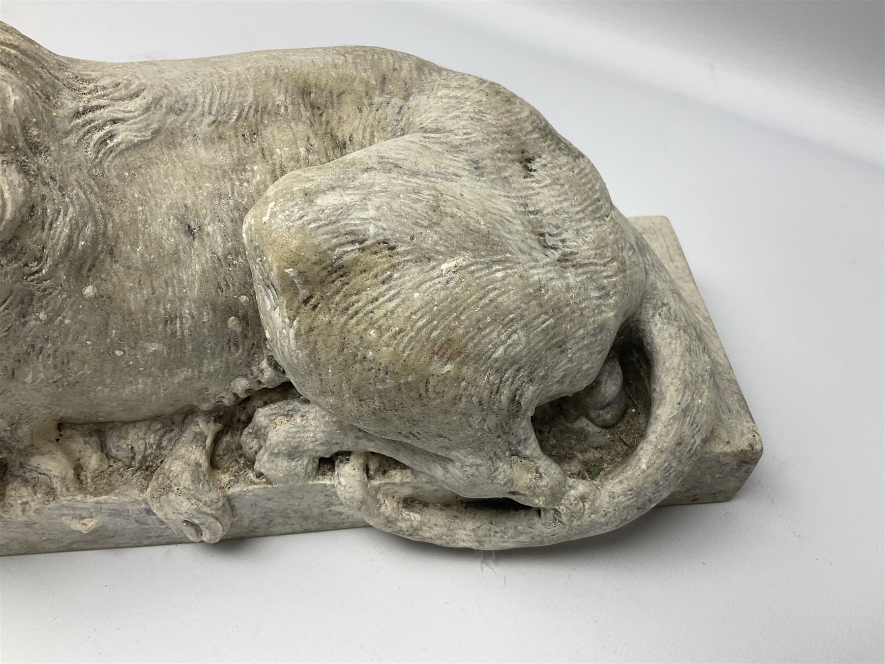 Two early 20th century reconstituted stone Grand Tour or Chatsworth House type lions after Antonio Canova, each modelled in recumbent pose upon a rectangular plinth, signed to plinth Dilettanti, each approximately L31cm