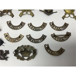 Over thirty British and Continental military metal badges; together with quantity of shoulder titles, collar dogs, rank pips, uniform buttons etc