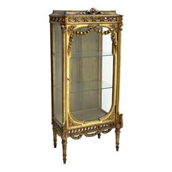 Late 20th century gilt wood and gesso display cabinet, the top decorated with ruffled ribbon above large single glazed door with floral and foliage garlands and moulded slip, interior fitted with two glass shelves, acanthus scrolls on stop fluted supports, pierced frieze with interlaced husk swags, W72cm, H163cm, D38cm