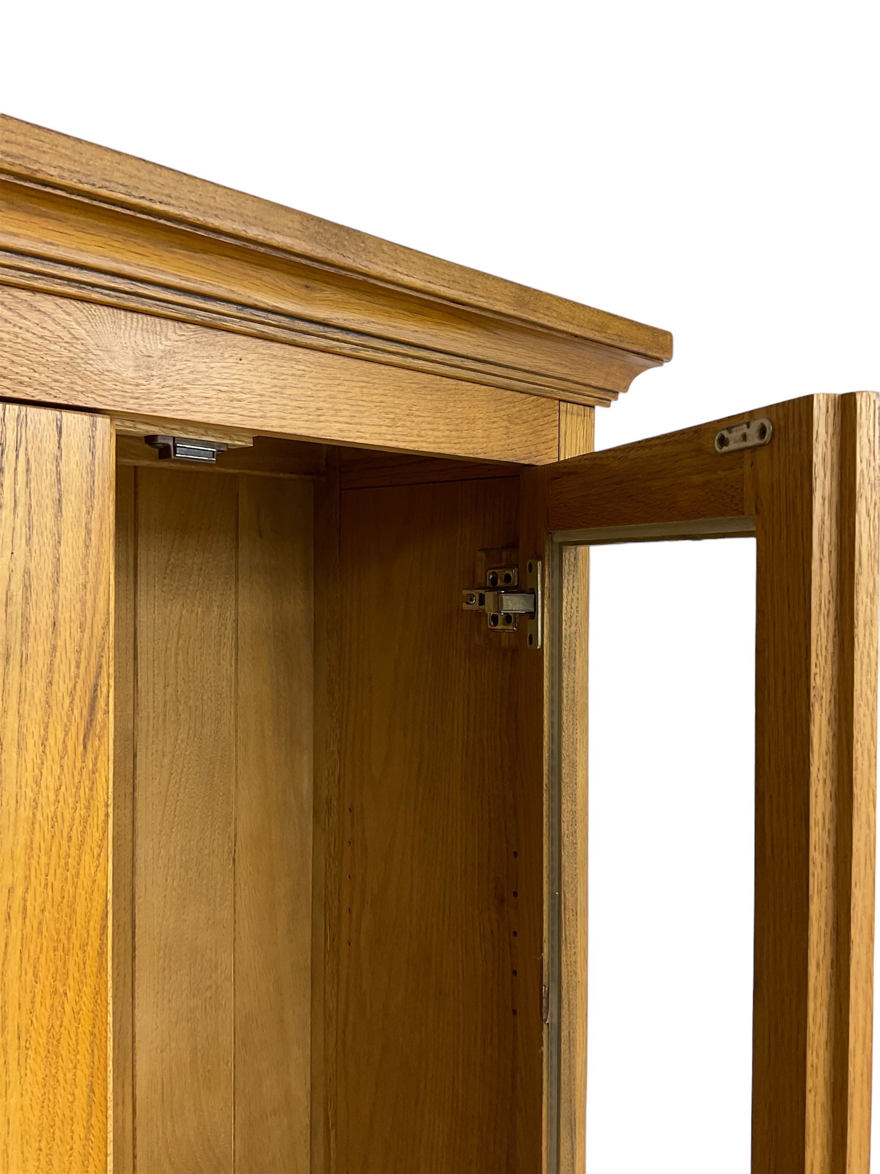 Tall oak display cabinet, projecting cavetto cornice over two glazed doors and single drawer, on bracket feet