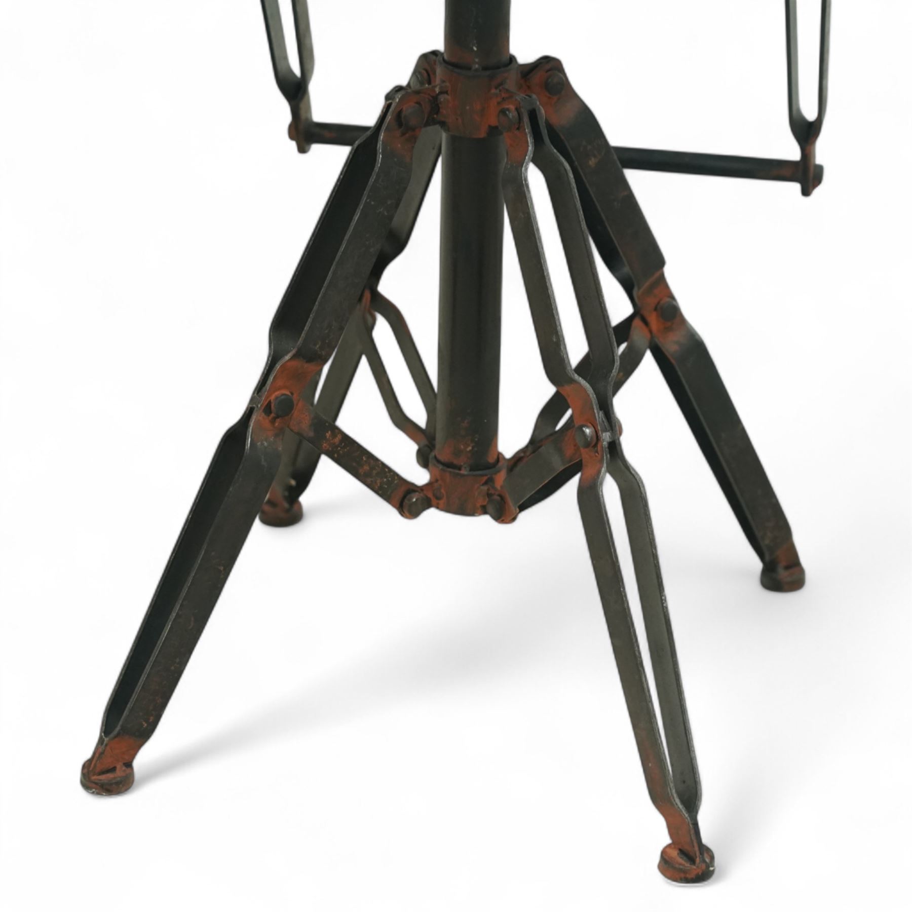 Pair of 20th century brutalist industrial metal swivel bar stools, sheet seats with strap backrests with bolted design to the sides, raised on quadripod bases with angular strut supports, the seats height-adjustable and swivelling