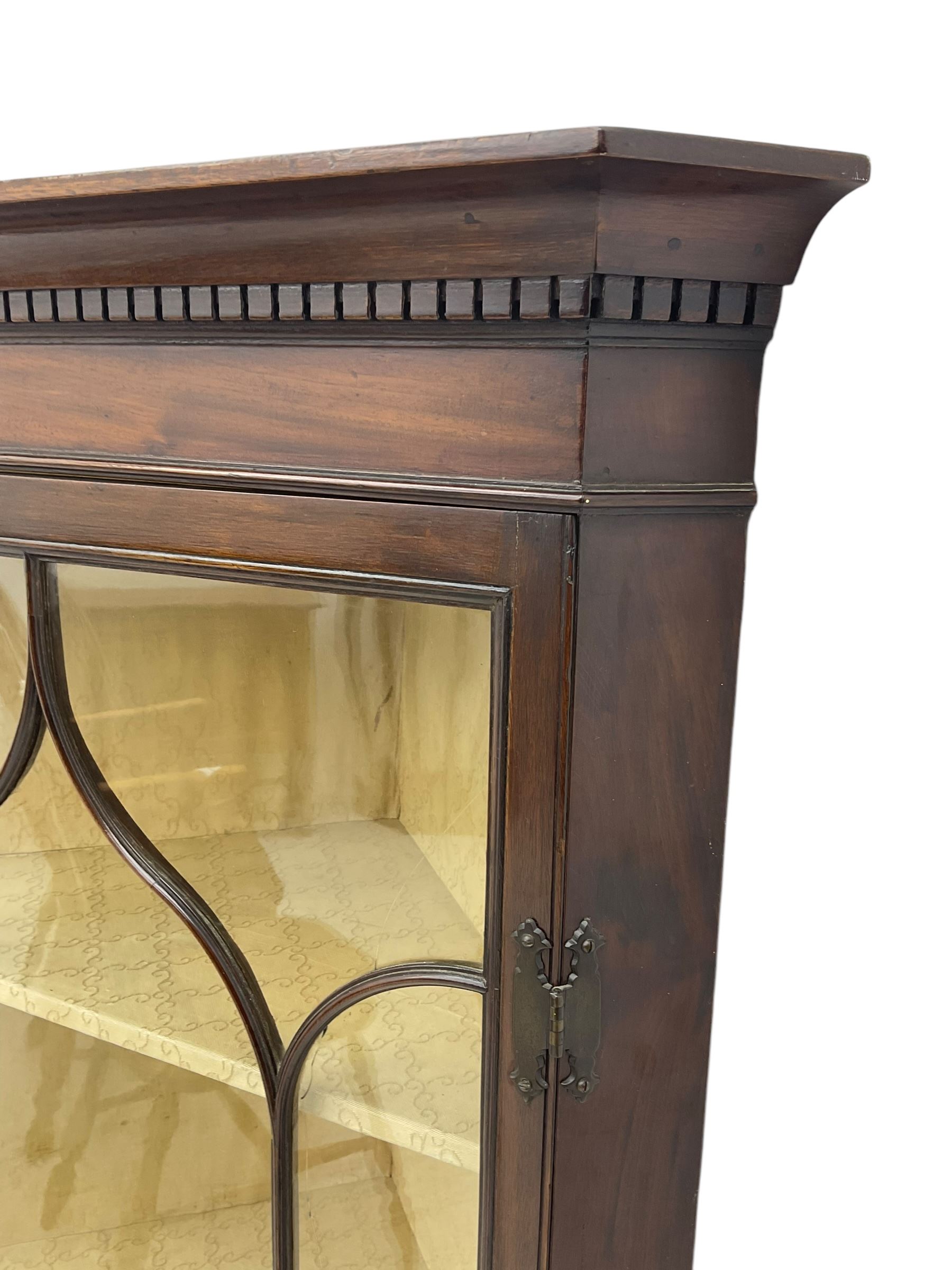 Early 20th century Georgian design mahogany wall-mounted corner display cabinet, projecting cornice with dentil frieze over astragal glazed door enclosing three fabric-lined shelves