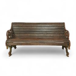 19th century oak and cast iron garden bench, shaped back and seat formed from curved wooden slats secured with dome rivets, pierced cast iron supports with foliate decoration 