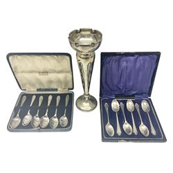 Early 20th century silver trumpet vase, upon knopped stem and circular filled foot, hallmarked Walker and Hall, Sheffield 1912, together with two cased sets of silver coffee spoons, all hallmarked