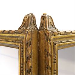 Early 20th century gilt and bevelled mirrored four panel folding screen, with two mirrors per side, flanked by beaded edges and scrolled finials, arcaded carved frieze
