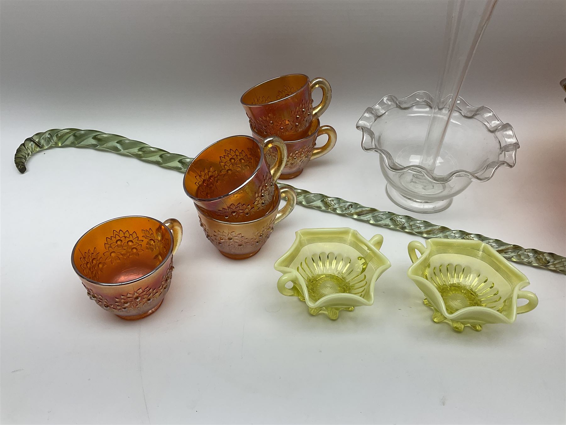 Amber carnival glass punch bowl and five cups with lustre finish, glass epergne with frilled rim and tall central trumpet, two lemon vaseline twin handled cups and a Victorian frigger cane, H87cm