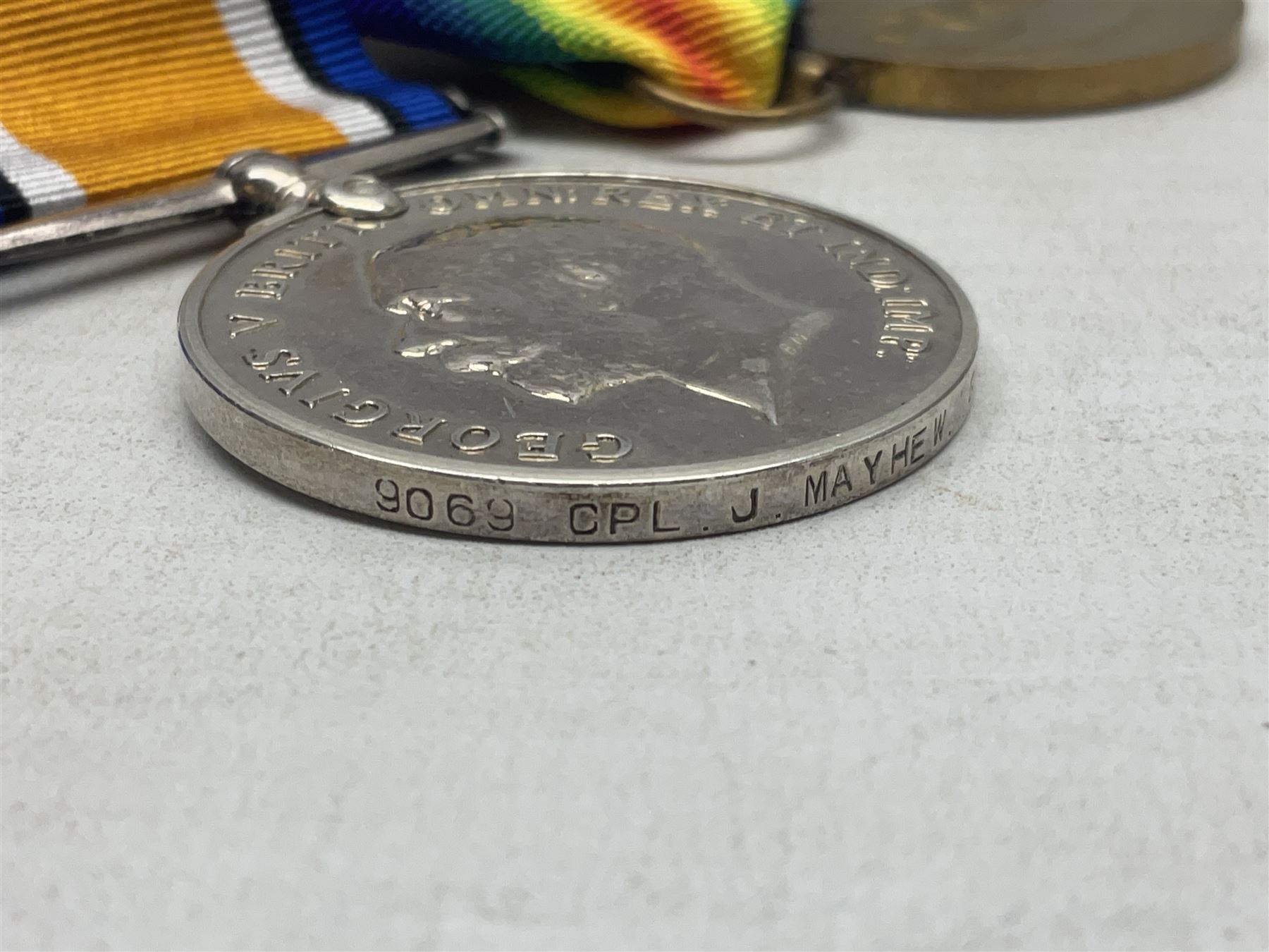 WW1 KIA group of three medals comprising British War Medal, 1914-15 Star and Victory Medal awarded to 9069 Cpl. J. Mayhew Glouc. R.; with ribbons; displayed on modern bar, and photograph of recipient in uniform; some biographical details