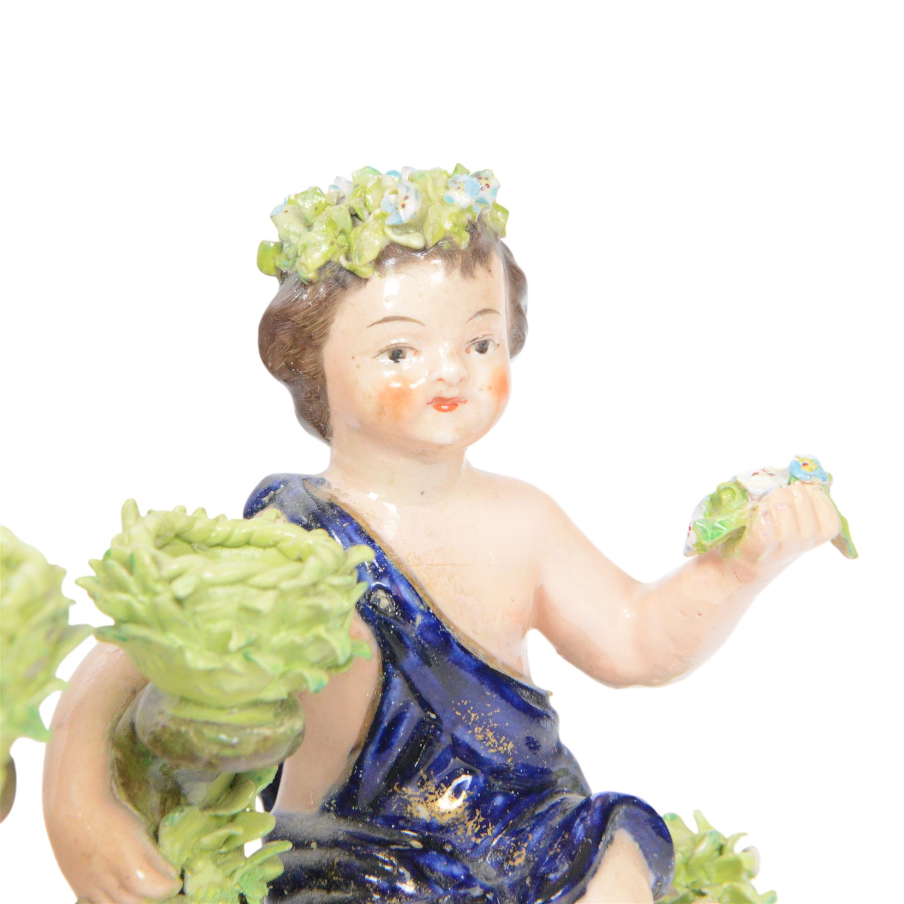 Pair of 19th century Stevenson and Hancock Derby figural chambersticks, each modelled as a seated cherub with arm around foliate encrusted sconce, marked beneath, H18cm