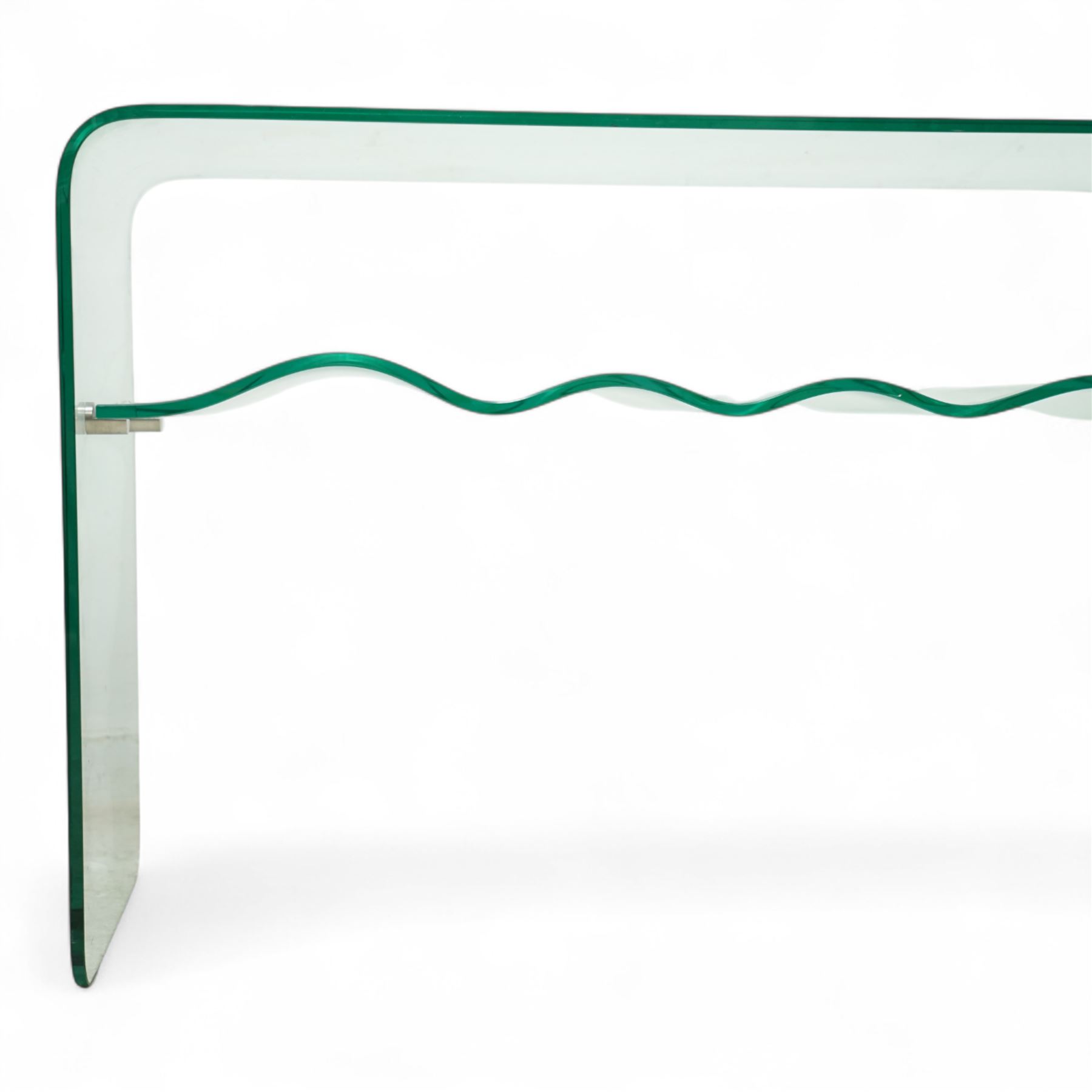 Contemporary glass two-tier console table of minimalist design, rectangular top with a single sheet of curved glass with a waved under tier supported with metal fittings 