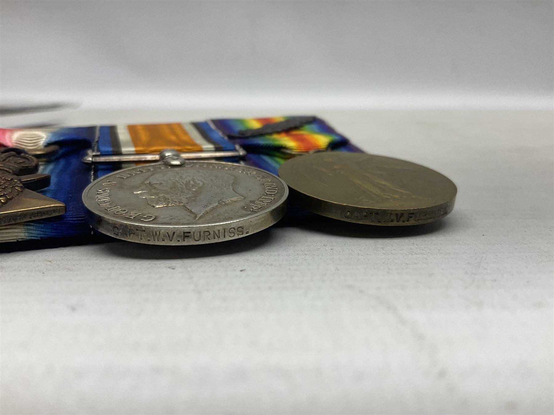 WW1 group of three medals comprising 1914-15 Star awarded to 1204 Pte. W.V. Furniss 20-London R. and British War Medal and Victory Medal with oak leaves awarded to Capt. W.V. Furniss; with ribbons; displayed on board for wearing; some biographical details