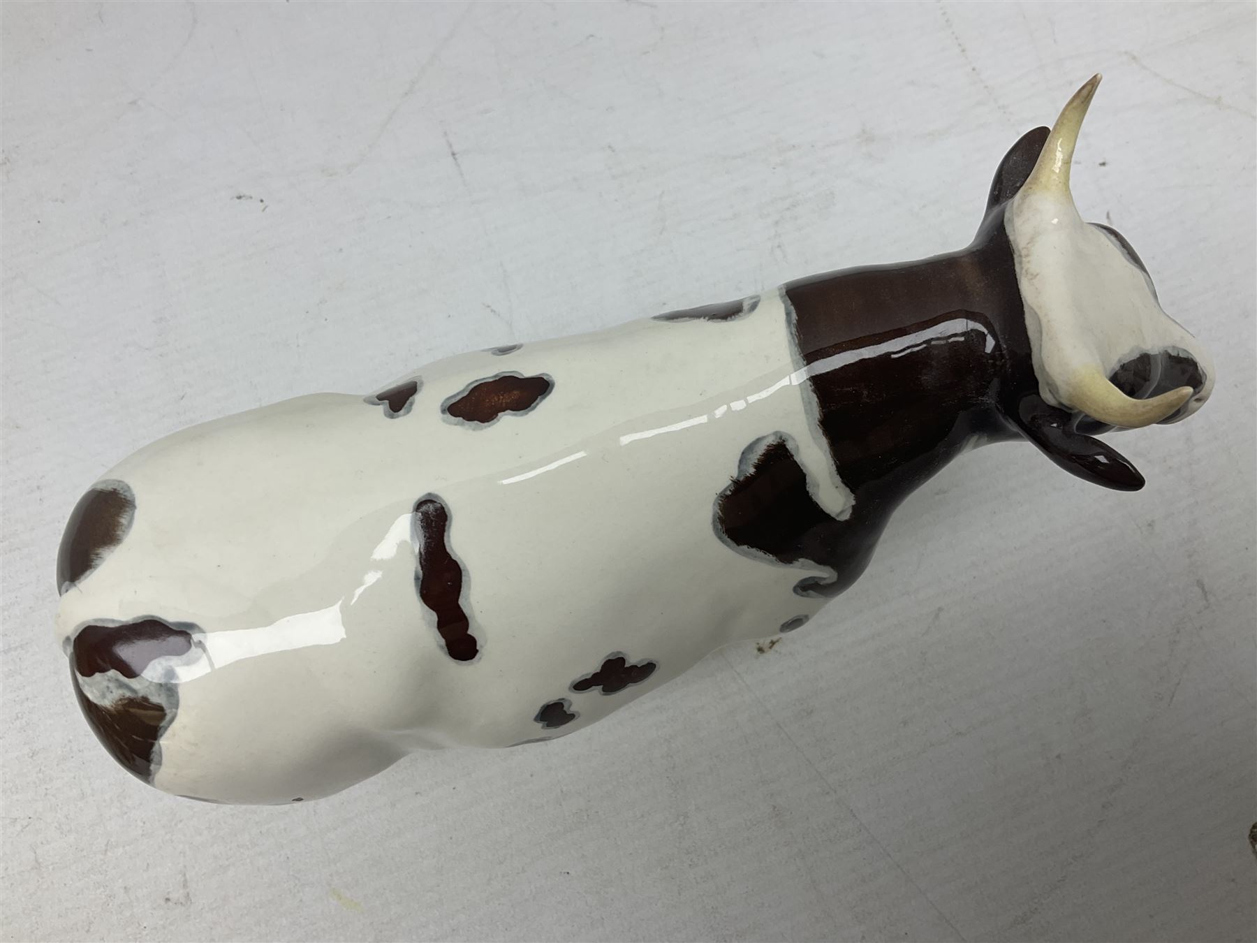 Five Beswick figures of cattle Comprising Ayrshire Bull Ch Whitehill Mandate, no 1454B, three Ayrshire Cow Ch Ickham Bessie, no 1350 and Ayrshire Calf, no 1249B, all with printed marks beneath