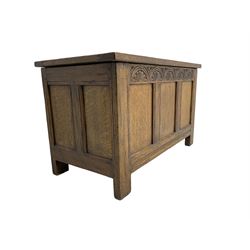 Mid-20th century panelled oak blanket box, triple panel lid and front, the frieze rail carved with lunettes, moulded rails and stile supports