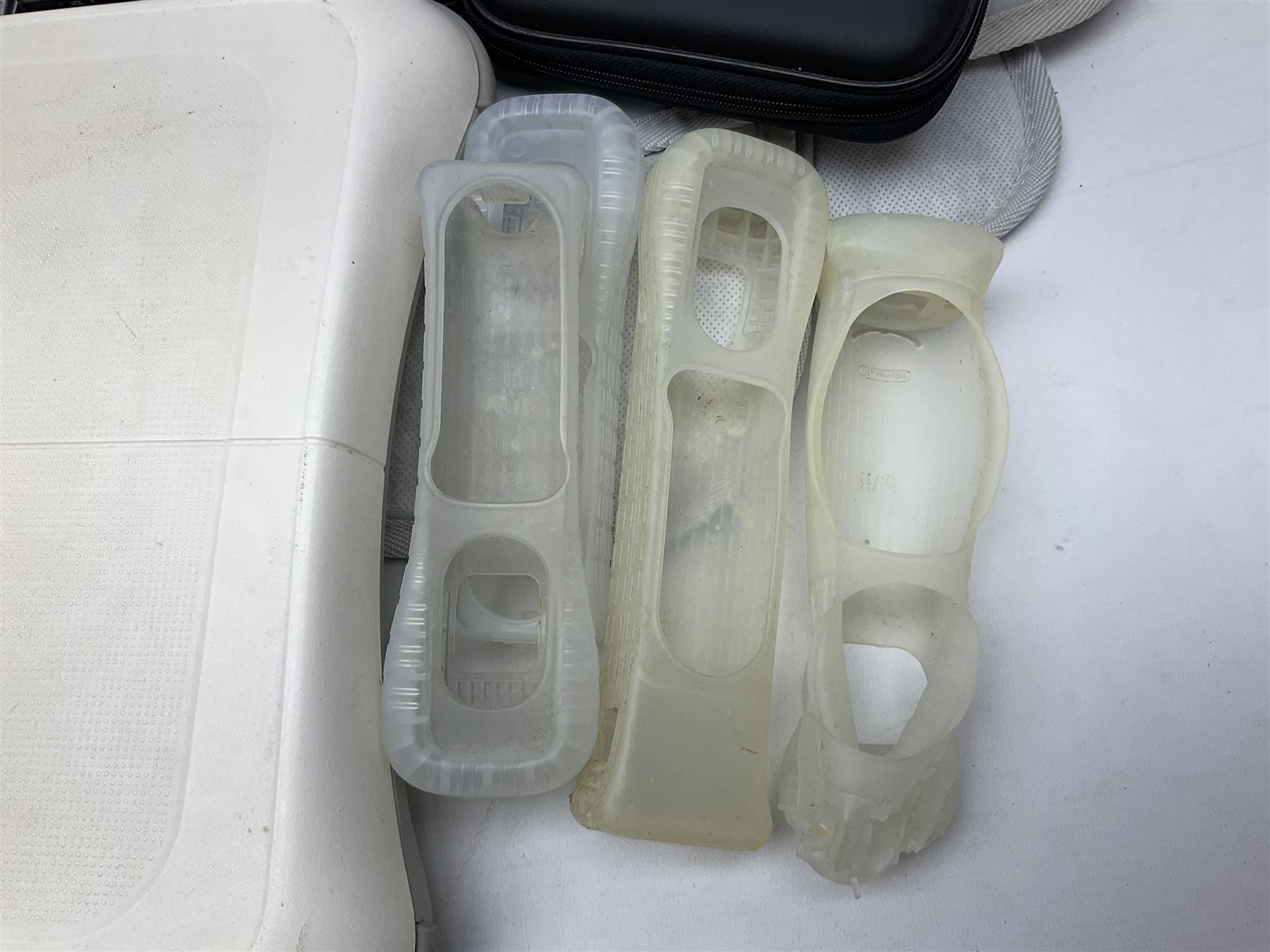 Nintendo Wii console, four controllers with cases and four nunchucks, Wii sensor bar, balance board and dance mat. Guitar hero wireless guitar for Wii and Redoctane wired guitar. Nintendo DS lite handheld gaming console, console and game cases and Guitar Hero Redoctane Guitar Grip. Selection of Nintendo Wii and Nintendo DS lite games to include Super Mario Galaxy, Guitar Hero, Wii Fit, Legend of Zelda games etc. Archos AV400 Series pocket video recorder with accessories, cradle and remote, in three boxes