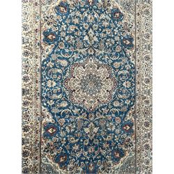 Persian Nain blue and ivory ground rug, wool with silk inlay, overall arabesque design, central medallion surrounded by interlacing and scrolled leafy branches and palmettes, the scrolling border decorated with stylised plant motifs, within guard stripes