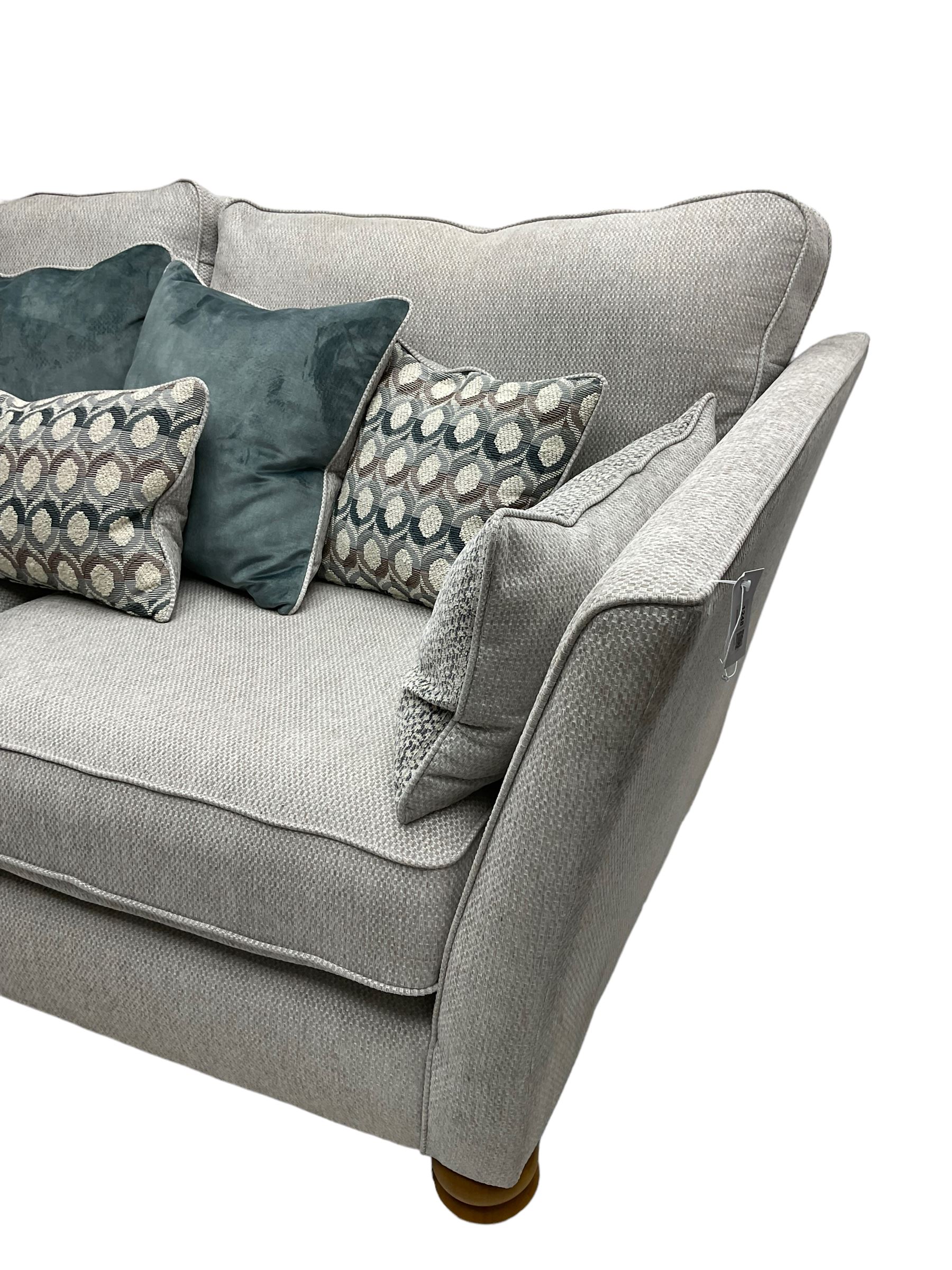 Oak Furnitureland - 'Gainsborough' lounge suite - three seat sofa, out-swept arms with loose cushions on turned oak feet, upholstered in 'Minerva Silver' fabric (W209cm D102cm H80cm); matching armchair or snuggler settee (W125cm); and rectangular ottoman footstool
