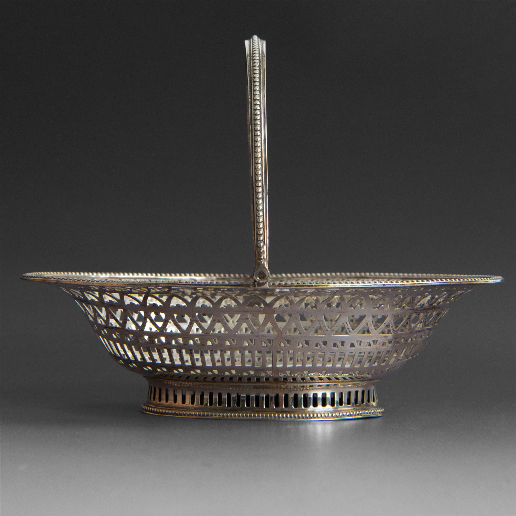 George III silver bon bon basket, of oval form with bead rim and swing handle, the sides with pierced latticework decoration, hallmarked Hester Bateman, London 1785, handle H14cm