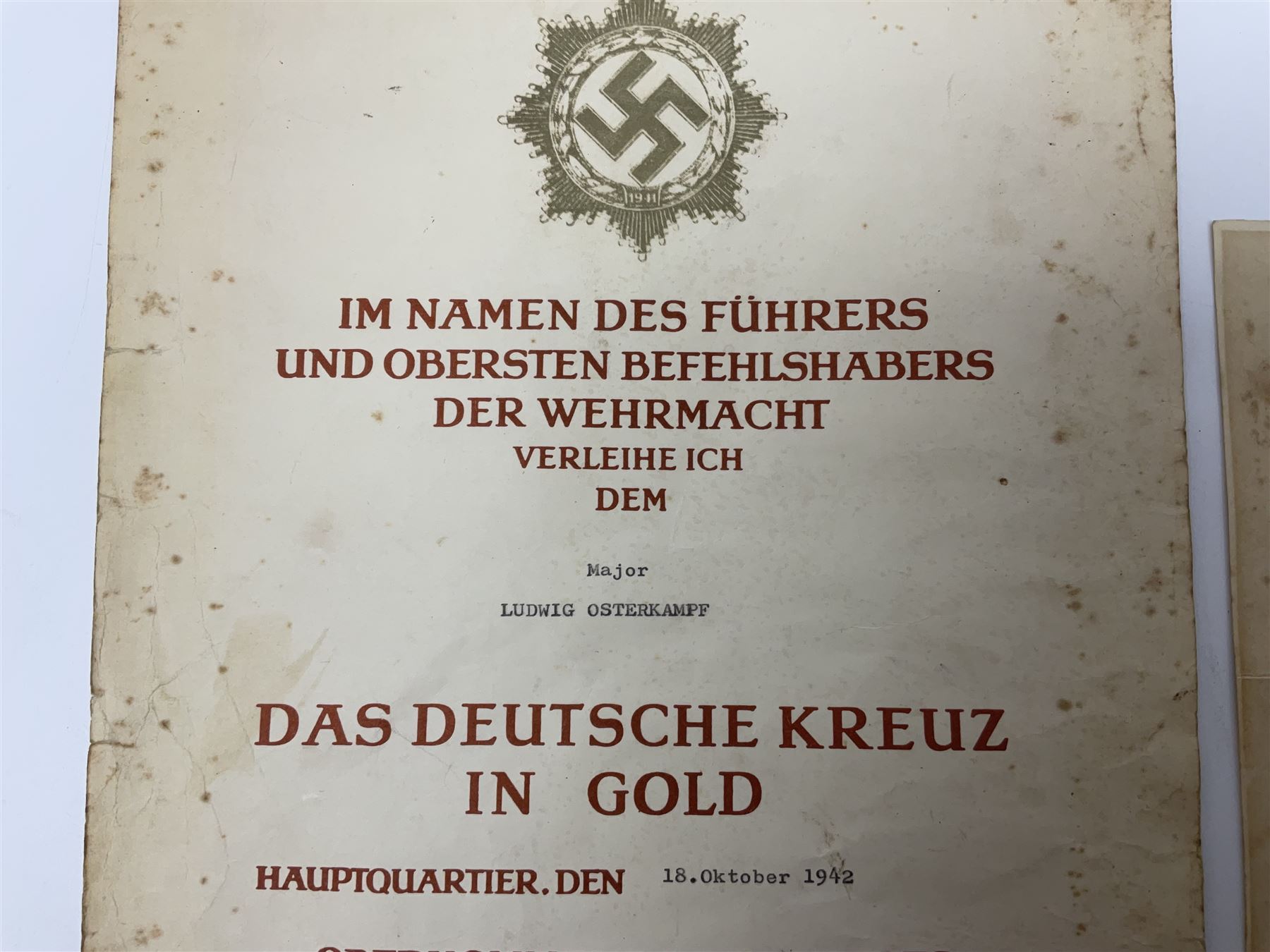Three German documents dated 1942 - Gold Cross award to Major Ludwig Osterkampf; and Crete wound certificate and cuff title certificate awarded to Feldwebel Alfred Glaise; all unframed (3)