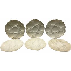 Set of six Minton white glazed oyster dishes, modelled as alternating scallop shells and fish, with printed marks beneath, D26.5cm.