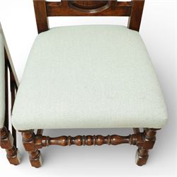 Country House oak high back dining chairs, set of ten comprising eight side chairs and two carvers, each with arched top rail flanked by turned finials over a central fielded panel back, with overstuffed seats upholstered in pale fabric, raised on turned front supports united by stretchers