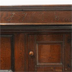 Early 18th century oak court cupboard, the projecting cornice carved with initials 'WKIW' and dated 1718 with turned terminals, fitted with two recessed panelled cupboard doors, large cupboard to base, raised on stile supports