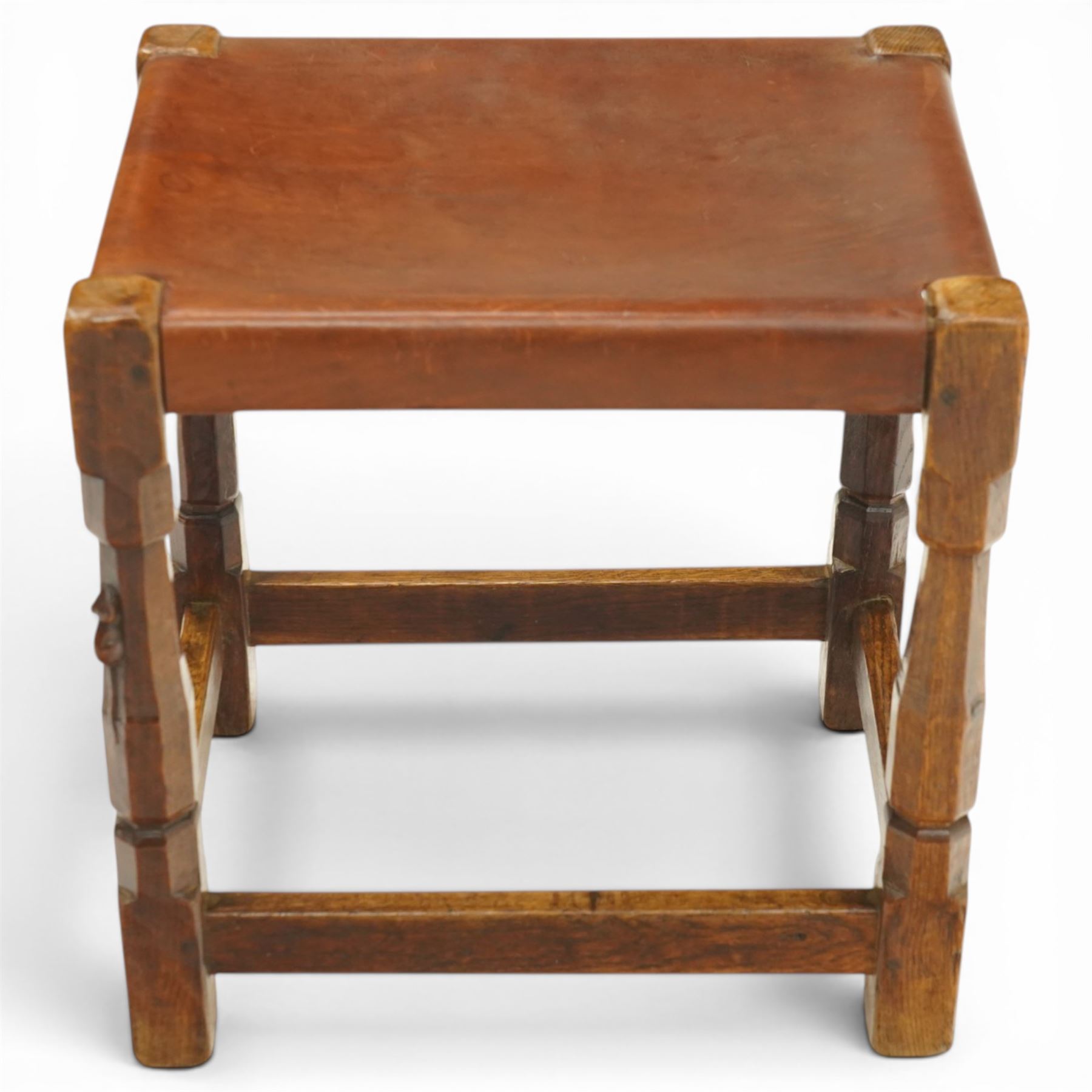 Mouseman - 1940s dark oak dressing table stool, the rectangular top with deep-tan leather seat, raised on octagonal supports united by box stretcher, with carved mouse signature, by the workshop of Robert Thompson of Kilburn