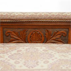 Late Victorian walnut chaise longue, upholstered in geometric patterned fabric, the scroll end and padded back above carved side panel with foliate and roundel motifs, shaped seat rail on turned front supports with ceramic castors