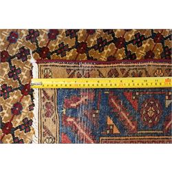 North East Persian Kurdie hand-knotted runner, camel ground with an all-over lattice of rosette motifs linked by angular vines, terminating in a stepped lozenge panel, with a madder red field, spandrels with geometric and zoomorphic devices, indigo main border of angular vines and repeating rosettes, flanked by narrow guard stripes, cotton fringe ends  