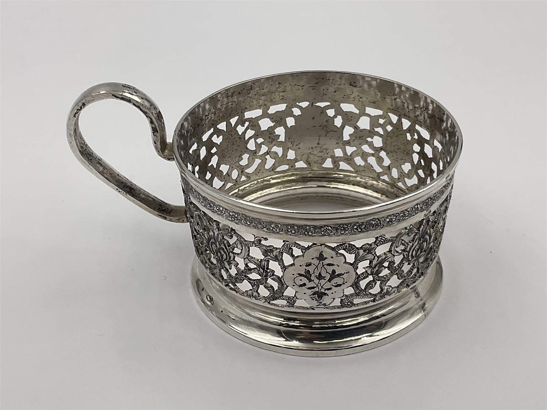 Early/mid 20th century Persian silver tea service, comprising circular serving tray, teapot, twin handled sucrier and cover, milk jug, five tea glasses with six silver holders, six tea spoons, and pair of sugar tongs, each profusely chased with foliate arabesque decoration, each bearing marks including 84 for 840 fineness, tray D40cm, teapot H16cm