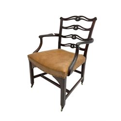George III mahogany elbow chair, ladder back with pierced and shaped slats carved with scrolls, seat upholstered in tan leather with studwork, scrolled arm terminal raised on chamfered supports joined by stretchers with brass castors