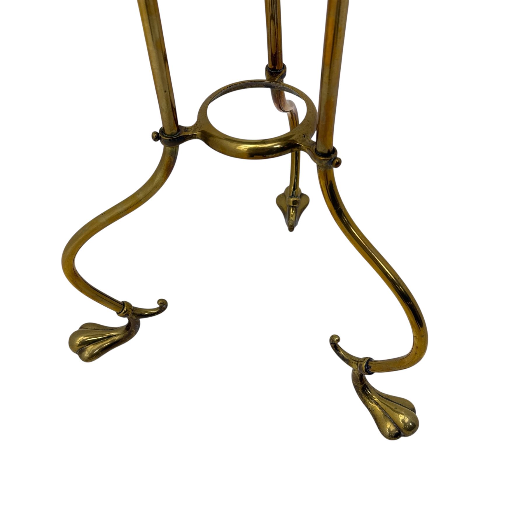 Edwardian oak and brass revolving magazine stand, arched frame with slatted slides and oak base, mounted on a brass column supported by three stylized scrolling legs terminating in pad feet
