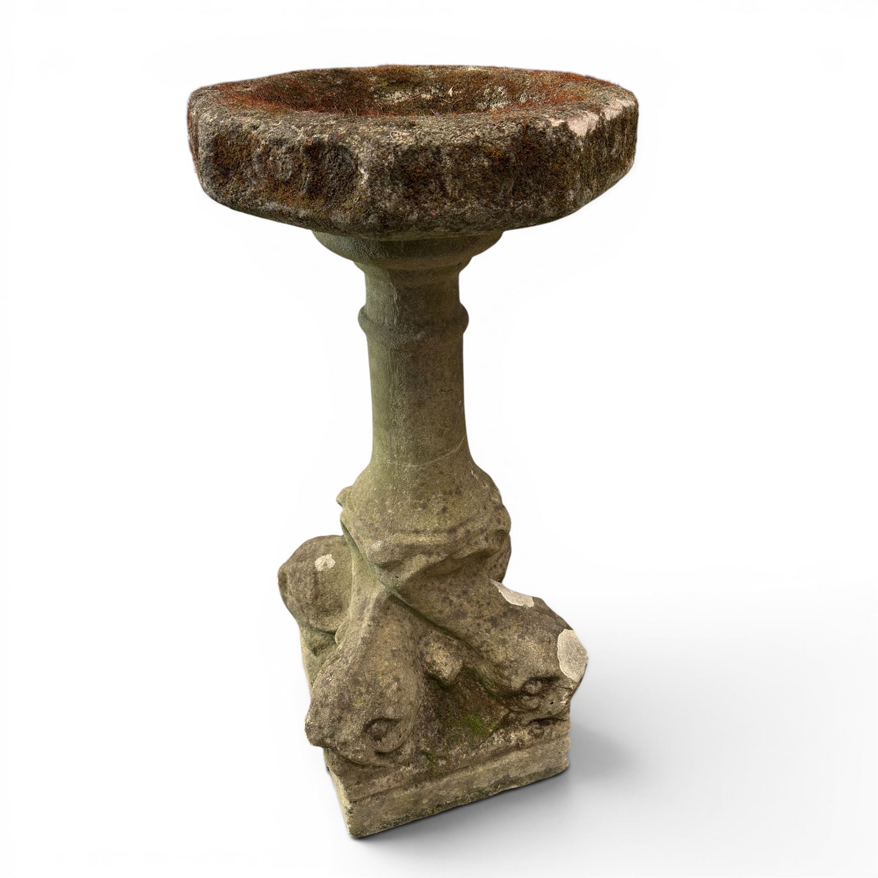 19th century weathered sandstone birdbath, the octagonal canted dished top raised on a ring turned flared pedestal, with four carved stylised dolphins to the squared base