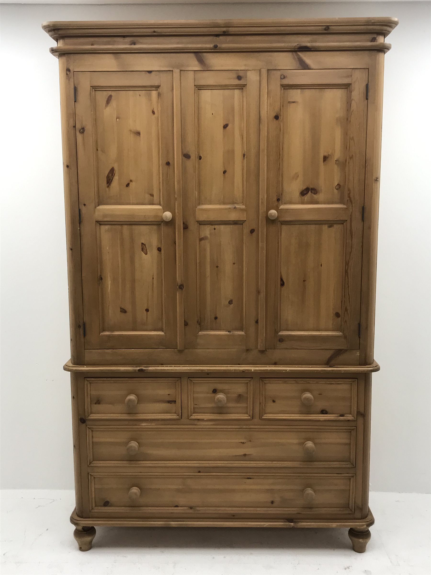 Waxed pine wardrobe enclosed by two panelled doors on chest fitted with