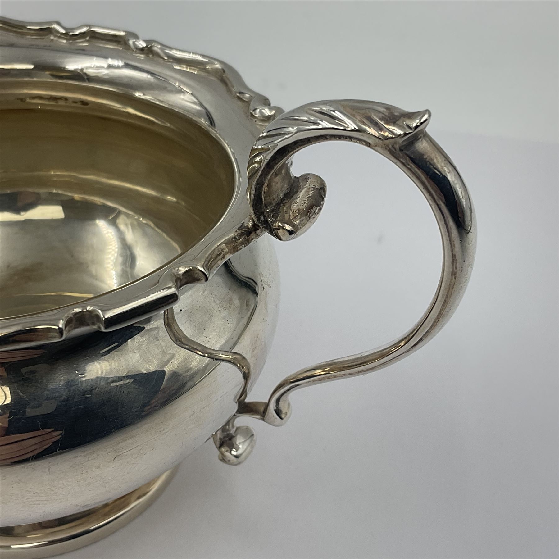 1920s five-piece silver tea service, comprising teapot, coffee pot, hot water pot, twin handled open sucrier and milk jug, each of squat circular form with shaped rim, the teapot, coffee pot and hot water pot each with ebonised handle and finial, the sucrier and milk jug with acanthus capped scroll handles, all upon circular foot, hallmarked R F Mosley & Co, Sheffield 1926 & 1927, tallest H24cm