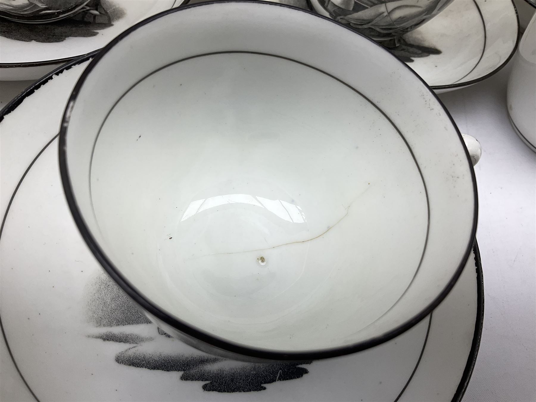 Early 19th century Staffordshire bat printed part tea service, decorated in black after Adam Buck with scenes of mother and child and other varying classical style scenes, within black bands, comprising teapot, slop bowl, jug, seven teacups and five saucers 